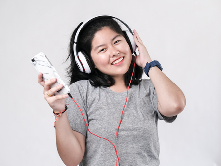Happy Asian teenager girl using headphone and listening music.の写真素材