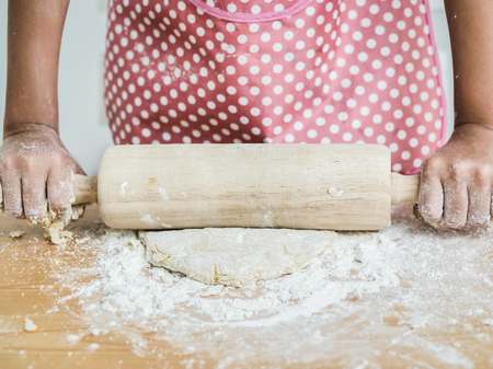 Asian girl rolling dough for making bread or pizza, lifestyle concept.