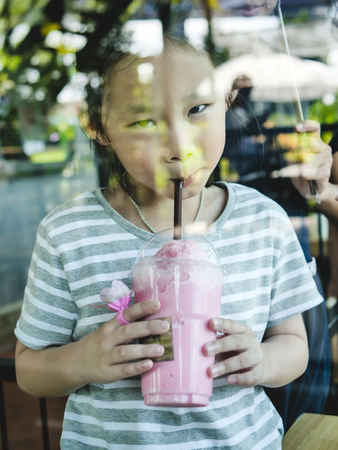 Happy Asian girl enjoy her drink in coffee shop, lifestyle concept.の写真素材