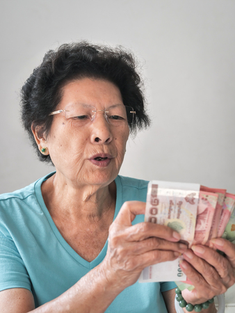 Senior woman receive subsistence allowance from government, lifestyle concept.