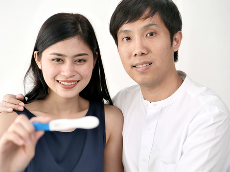 Woman and man holding Pregnancy test and see the result, conceptual.