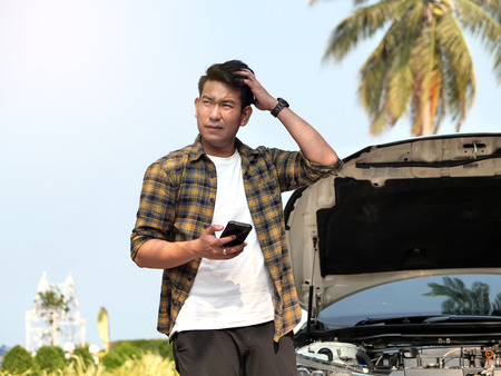 Man is calling a car mechanic and he very stressed because of his car breakdown