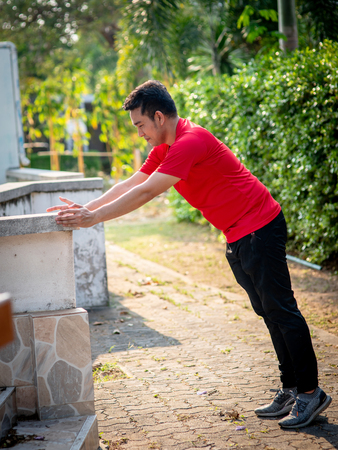 Happy Asian sport man doning exercise in the park outdoor.