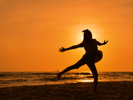 Silhouette girl dancing ballet on the beach in sun rise.の写真素材