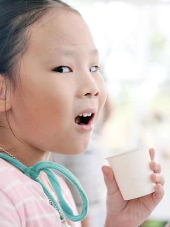 Happy Asian girl drinking a paper cup of water, lifestyle concept.の写真素材