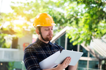 Male engineer at a construction site with a tablet computerの写真素材