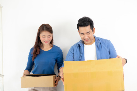 Happy Asian couple holding brown boxes  and moving to new house, lifesetyle concept.の写真素材