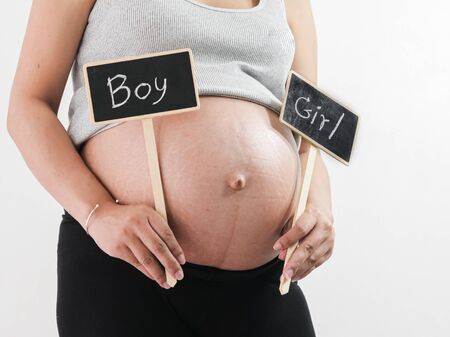 Happy Asian pregnant woman showing boy or girl blackboard, lifestyle concept.の写真素材