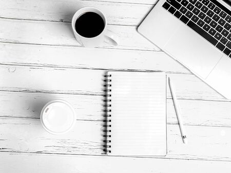 Office desk table with computer, supplies, cup of coffee. White wooden background. Coffee break,...