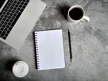 Laptop, supplies, cup of coffee. gray texture background. Coffee break, ideas, notes, goals or plan...