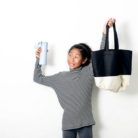 Asian girl holding fabric handbag and water drink bottle eco waste zero living concept.の写真素材