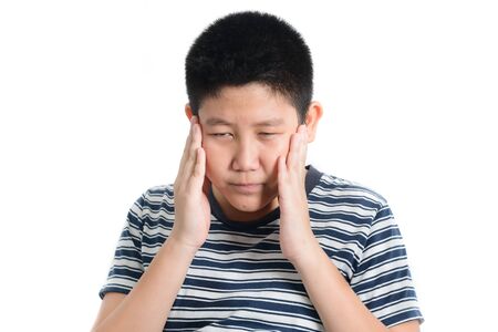 Asian preteen boy having headache on white background.の写真素材
