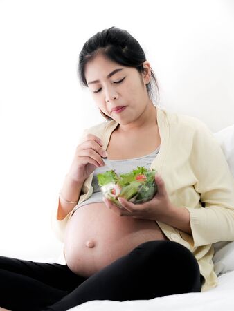 Asian pregnant woman eating fruit salad, lifestyle concept.の写真素材