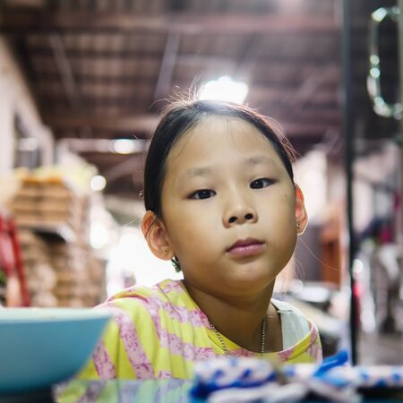 Cute Asian girl eats fried rice for breakfast at home.の写真素材
