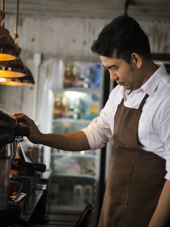 Happy Asian barista man working in cafe, lifestyle concept.の写真素材