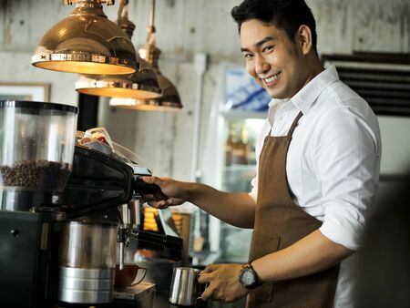 Happy Asian barista man working in cafe, lifestyle concept.の写真素材