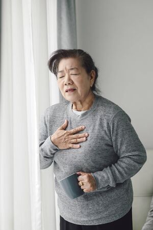 Asian senior woman have a heart attack at home, lifestyle concept.の写真素材