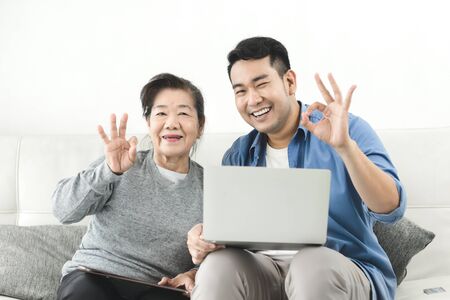 Asian agent man deal with senior for life insurance contract signed, business concept.