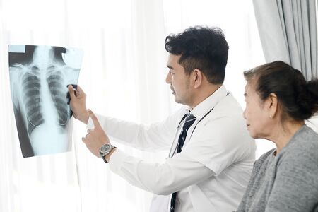 Doctor showing x-ray results to elderly womanの写真素材