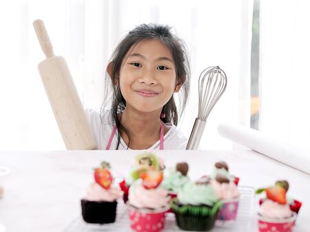 Girl with homemade cupcake on table, selective focus, lifestyle concept.の写真素材