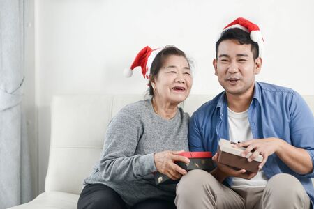 Asian mother and son holding gift box for christmas concept.