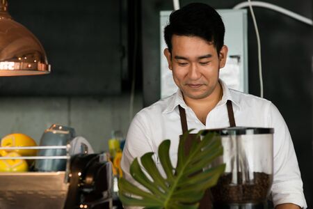 Happy Asian barista man working in cafe, lifestyle concept.の写真素材