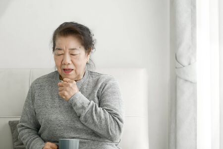 Asian senior woman have a cough at home, lifestyle concept.の写真素材