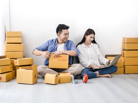 Asian couple with stack of parcel boxes, online business and delivery concept.の写真素材