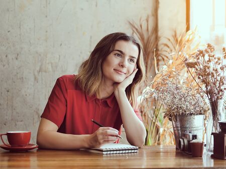 Beautiful woman thinking for idea with her work in coffee shop, lifestyleの写真素材