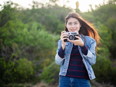 Happy Asian woman vintage camera with nature background, camping concept.