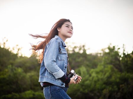 Happy Asian woman vintage camera with nature background, camping concept.の写真素材