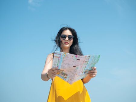 Asian tourist with map with blue sky, lifestyle concept.の写真素材