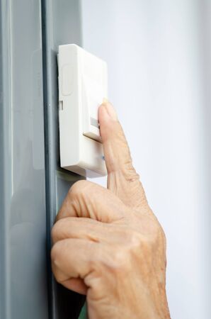 Asian senior woman clicking door bell, lifestyle concept.
