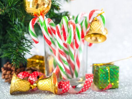 Christmas candy sticks on glass with silver bokeh background.の写真素材