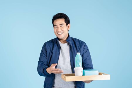 Delivery man is carrying food pakage for takeaway food and drink on blue background.の写真素材