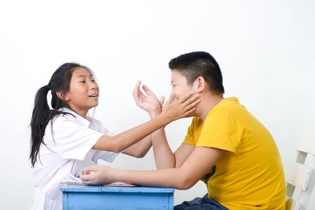 Asian children playing doctor at home, girl doctor checking up her patient.