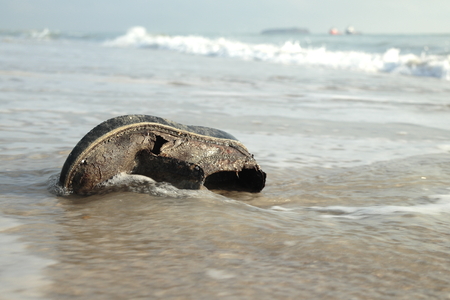 waves to the shore. It brings all kinds of garbageの写真素材
