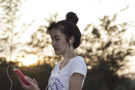 Cute woman listening to music with mobile and happyの写真素材
