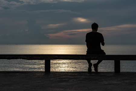 Man sitting watching the sea splendor of nature.の写真素材