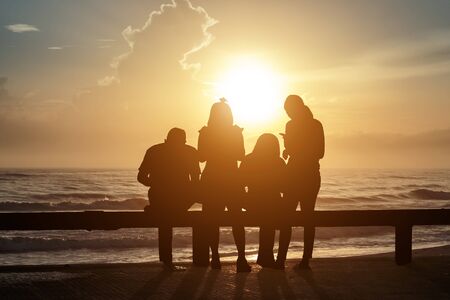 The tourist Both women and men take photos and enjoy the scenery. Sunrise from the seaの写真素材