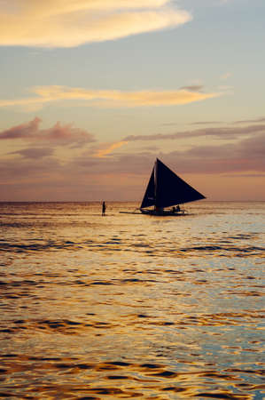 Beautiful colorful sunset over fishing boats and people in water