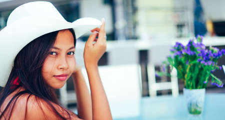 Beautiful young woman smiling with the hat on the beach ressort, summer vacationの写真素材