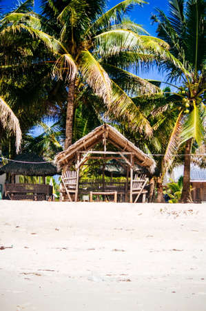 Landscape of paradise tropical island with palms, cottages and white sand beachの写真素材