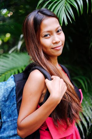 Girl with blue backpack in tropical forestの写真素材