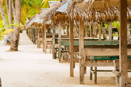 Nipa huts on the white coral sand beach surounded with palmsの写真素材