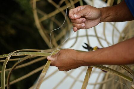 Man making object from bamboo by hand