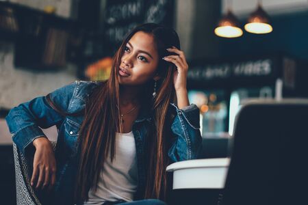 Gorgeous young woman in blue jeans chilling in a barの写真素材