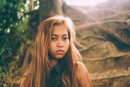 Portrait of young beautiful seductive girl in the forestの写真素材