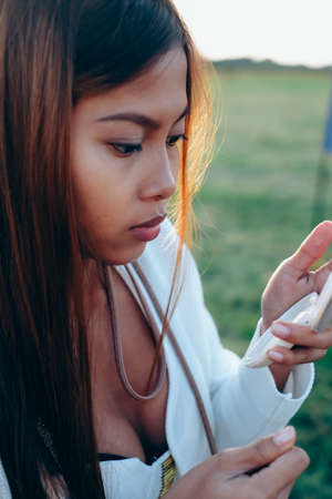Beautiful girl looking at the small makeup pocket mirrorの写真素材