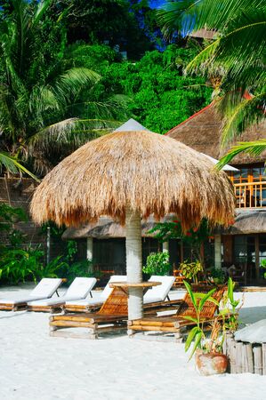 Landscape of paradise tropical island with palms cottages and white sand beachの写真素材